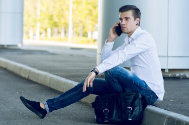 konuşmak Smartphone road yakınındaki otururken yakışıklı genç