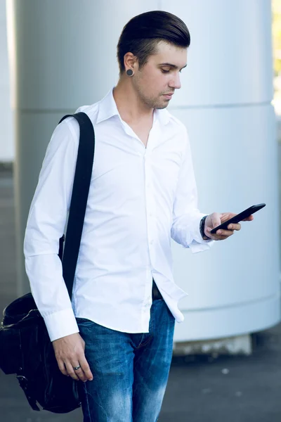 Homem usando telefone inteligente na estação para reservar bilhetes de avião — Fotografia de Stock
