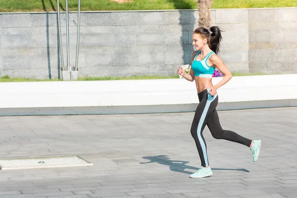 Young happy woman jogging in town — ストック写真