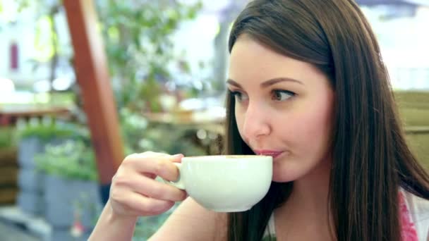 Mujer tomando café en la cafetería de la calle, sonriendo, feliz — Vídeo de stock