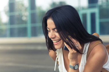 Genç bir kadın cep telefonuyla konuşuyor.