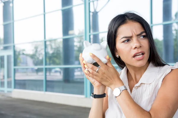 Jovem mulher preocupado com vazio porquinho banco — Fotografia de Stock