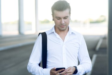 Kitap uçak bileti için istasyonunda akıllı telefon kullanan adam