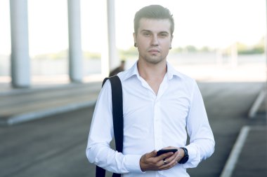 Kitap uçak bileti için istasyonunda akıllı telefon kullanan adam