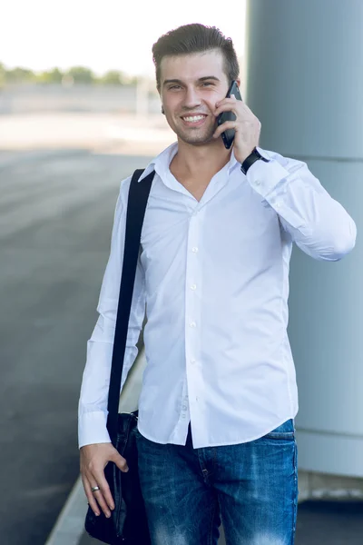 Hombre guapo en el teléfono móvil en la estación del pasillo — Foto de Stock