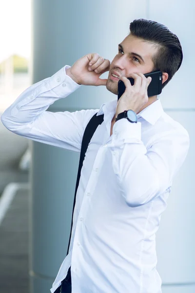 Hombre guapo en el teléfono móvil en la estación del pasillo — Foto de Stock