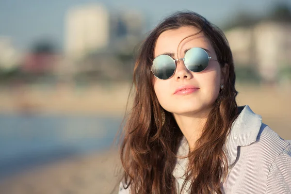 Портрет красивой молодой женщины в очках у моря — стоковое фото
