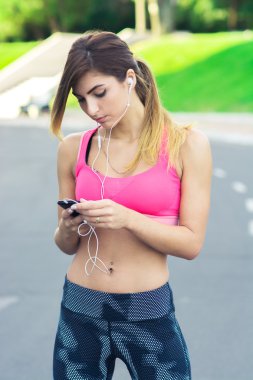 Genç kadın atlet koşmak önce müzik açar