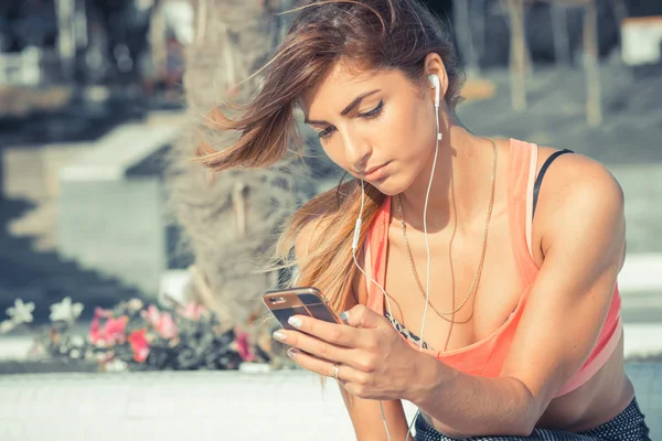 Hermosa atleta de fitness mujer escuchando música después del ejercicio — Foto de Stock