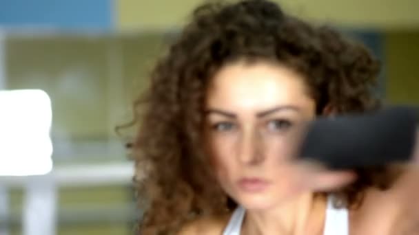 Athlétique jeune femme bouclée ombre boxe, vue de face, ralenti — Video