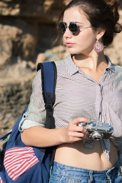 Молодая женщина-путешественница улыбается с камерой в руке — стоковое фото