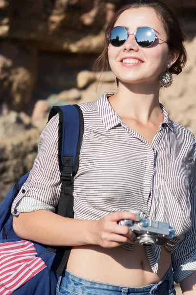 Joven viajera sonriendo con la cámara en la mano — Foto de Stock