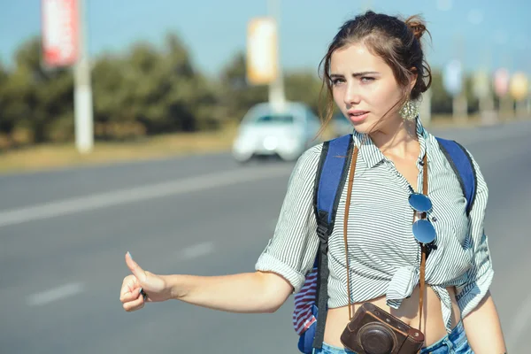 Travel woman hitchhiking. Beautiful young female hitchhiker