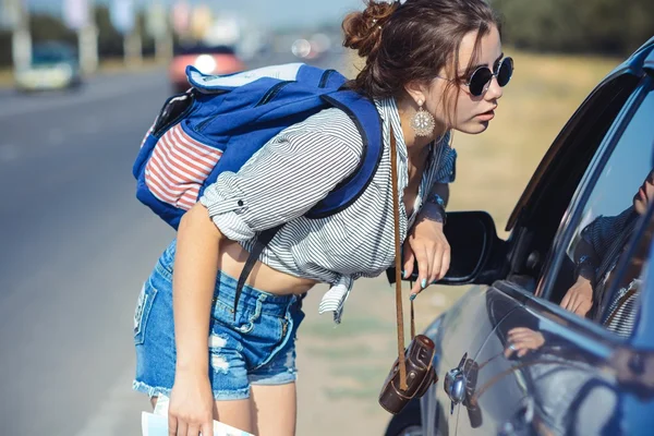 Młody Autostopowicz kobieta prosi droga do sterownika — Zdjęcie stockowe