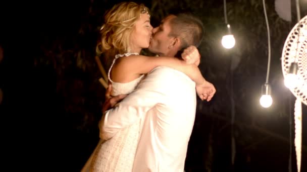 Sposi che ballano e si baciano in un ambiente romantico con accendino di notte — Video Stock