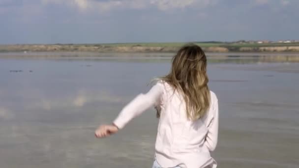 Zorgeloze vrouw in casual loopt op ondiep van meer in de zomer — Stockvideo