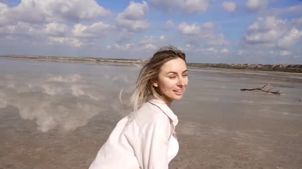 Meisje bij het meer aan de oever, rennen en wandelen op de kust plezier maken - spiegel reflectie hemel — Stockvideo