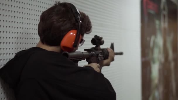Людина стріляє на вогнепальній відстані в захисних навушниках — стокове відео