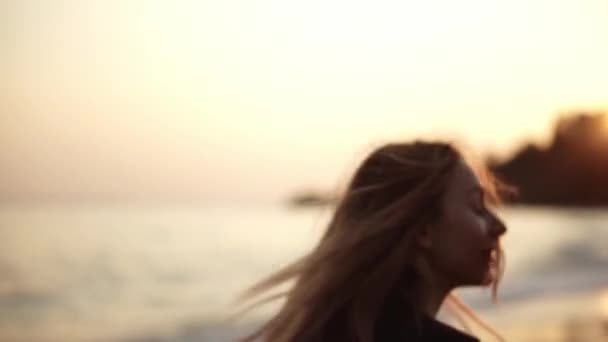 Een vrouw loopt langs het strand van achteren, aan de kust 's avonds van de herfst — Stockvideo