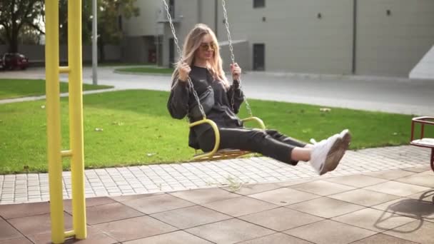 Femme aux cheveux longs se balançant sur une balançoire dans le parc verdoyant calmement — Video