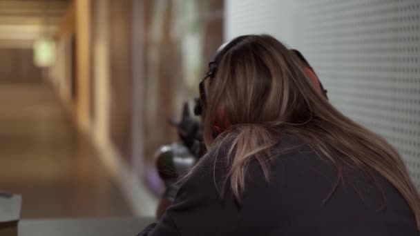 Mulher com rifle nas mãos ao alcance de tiro com alvo, animado e surpreso — Vídeo de Stock