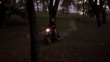 Çekici adam ağaçlar ve ormanlar arasında motosikletle ülkeyi boydan boya geçiyor.