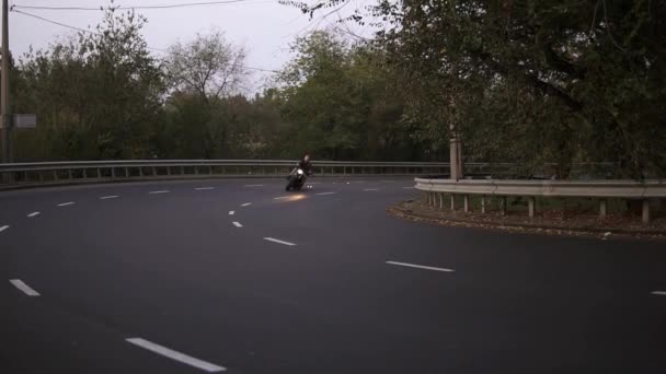 Un homme monté sur une moto dans un virage s'accroche à l'asphalte, des étincelles volent — Video