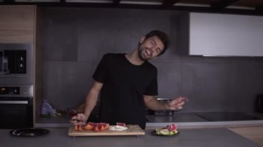 Evde dans edip şarkı söylerken mutfakta vejetaryen kahvaltısı hazırlayan komik adam.