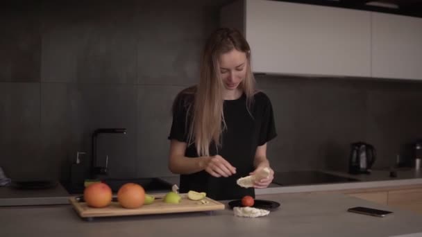 Donna pulisce fetta pomelo in cucina su un bancone — Video Stock