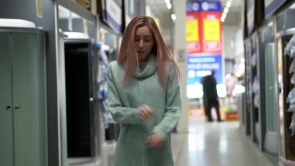 Vrouw danst in hardware winkel tussen de rijen — Stockvideo