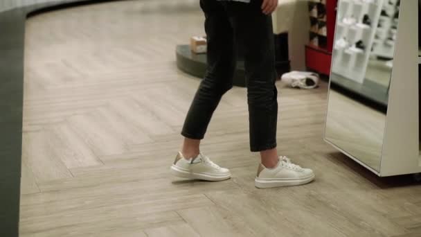 Vrouw past nieuwe witte sneakers in schoen winkel, proberen beste maat — Stockvideo