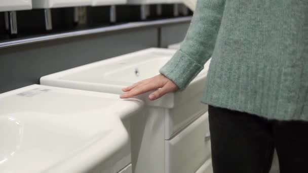 Woman is choosing a new ceramic sink in a store — Stock Video