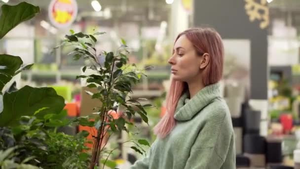 Mulher loira escolhendo plantas no mercado de flores na loja de jardim — Vídeo de Stock