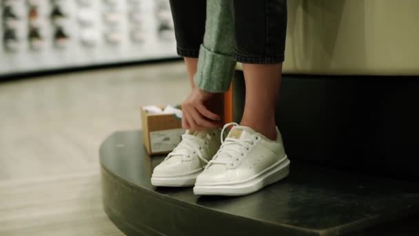 Femme est d'essayer de nouvelles baskets blanches dans le magasin de chaussures — Video