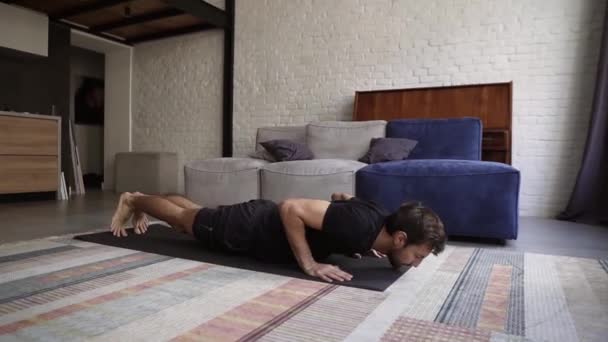 Άντρας κρατώντας τα χέρια στο πάτωμα και κάνοντας push-up άσκηση στο σπίτι — Αρχείο Βίντεο