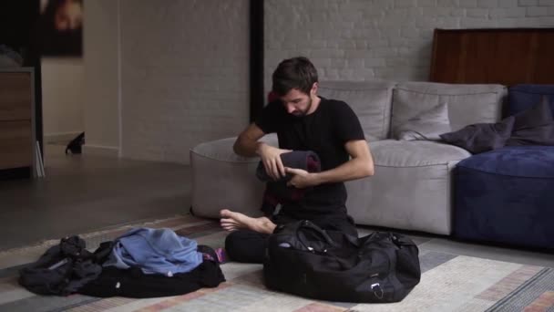 Un hombre empacando una maleta o equipaje para viajar en el salón — Vídeos de Stock