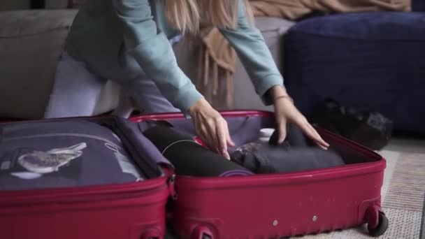Tunnistamaton nainen hotellihuoneessa laittaa tavarat matkalaukkuun, lähikuva — kuvapankkivideo