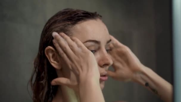 Retrato de una mujer lavándose el cabello con champú en la ducha — Vídeos de Stock