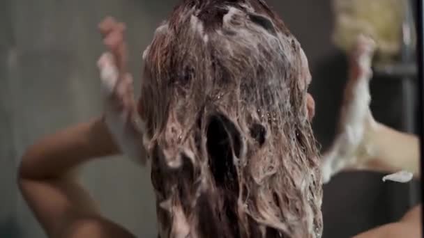Sällsynta bilder av en kvinna som tvättar håret med schampo i duschen — Stockvideo