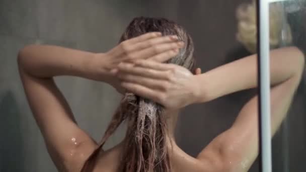 Sällsynt bild av en kvinna sköljer håret efter schampo i duschen — Stockvideo