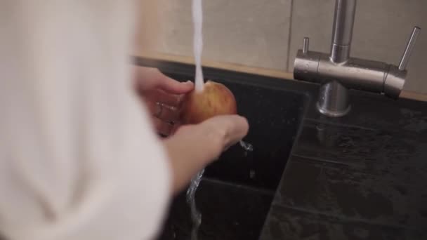 台所のシンクでリンゴを洗う女性の手 — ストック動画
