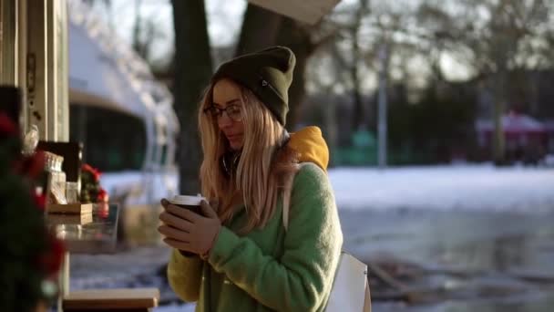 冬天散步时在街上的咖啡店里喝咖啡的女人 — 图库视频影像