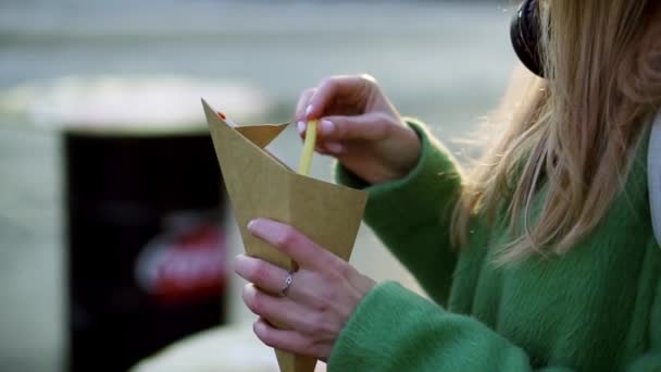 Žena jíst hranolky venku na zimní ulici dip v kečupu — Stock video