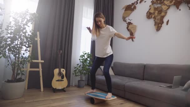 Mujer divertida en la cubierta para el equilibrio se para con los pies, fingiendo que está surfeando — Vídeos de Stock