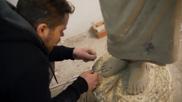 Vista ad alto angolo di piedi statua Buddha argilla, artista lavora con dettaglio utilizzando strumenti — Video Stock