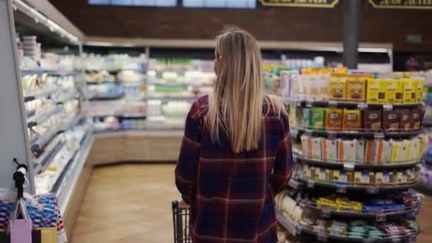 블 론드 여성, 검역 기간에 슈퍼마켓에서 카트를 들고 다닌다 — 비디오