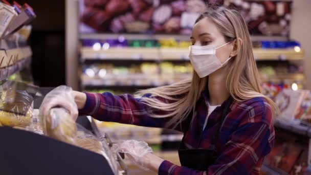 Kvinnlig personal i mask som arbetar på bageriavdelningen i snabbköpet — Stockvideo