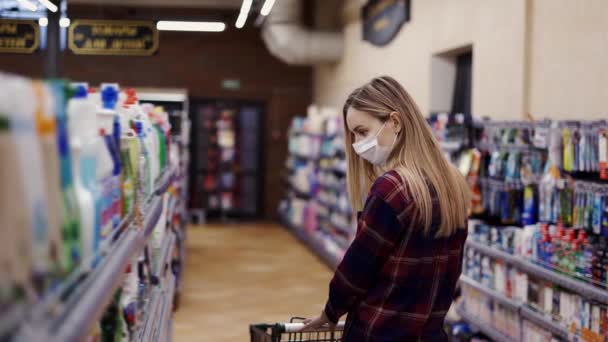 Mulher escolhendo detergente em um produto doméstico na loja — Vídeo de Stock
