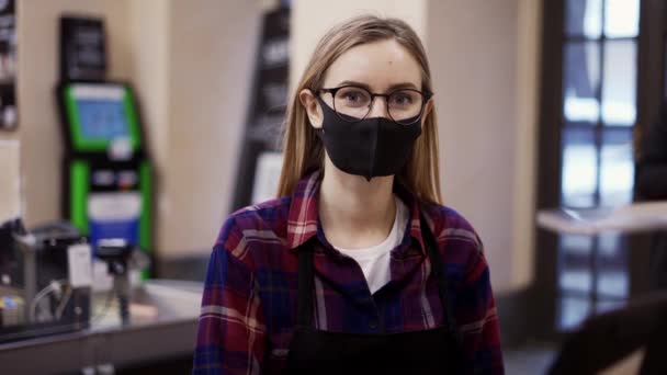 Portrait of a woman in a medical mask working at the checkout in a supermarket — Stock Video