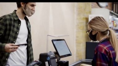 Kontrol gişesi müşterisi yiyecekleri için akıllı telefon ile süpermarkete ödeme yapıyor.
